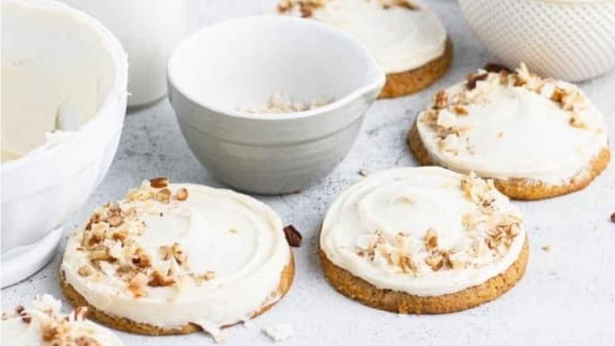 A plate of cookies with icing and pecans.