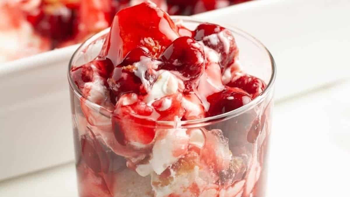 A glass filled with cranberry ice cream and whipped cream.