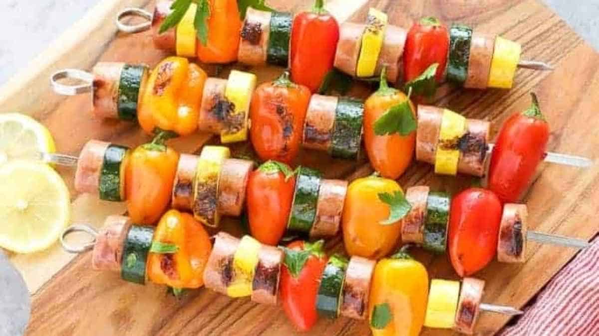Grilled vegetable skewers on a wooden cutting board.