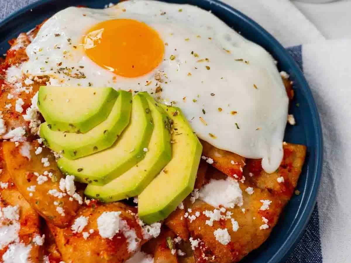 A plate with a fried egg and avocado on it.