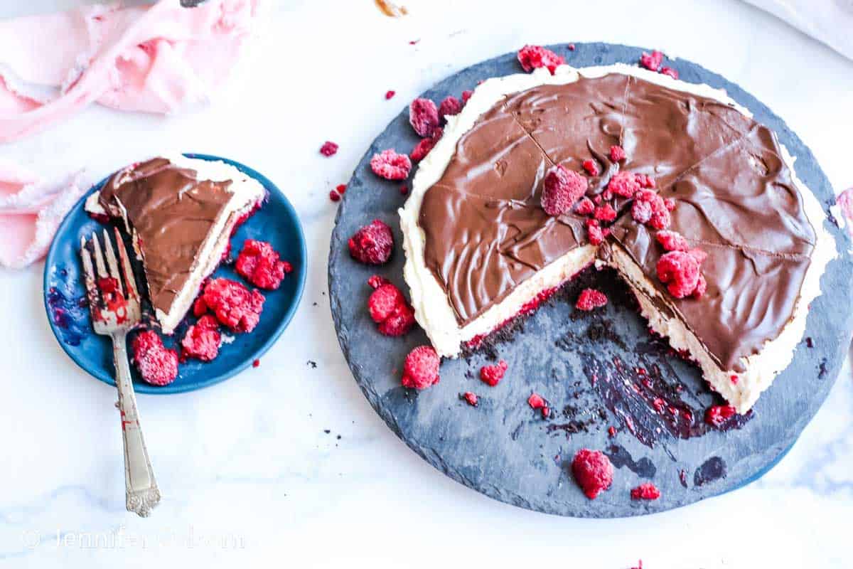 A slice of chocolate cake with raspberries on a plate.