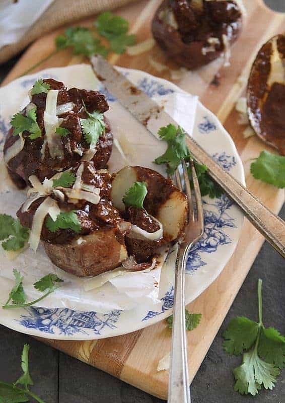 Delicious stuffed potatoes with tender chuck steak and gooey cheese on a plate.