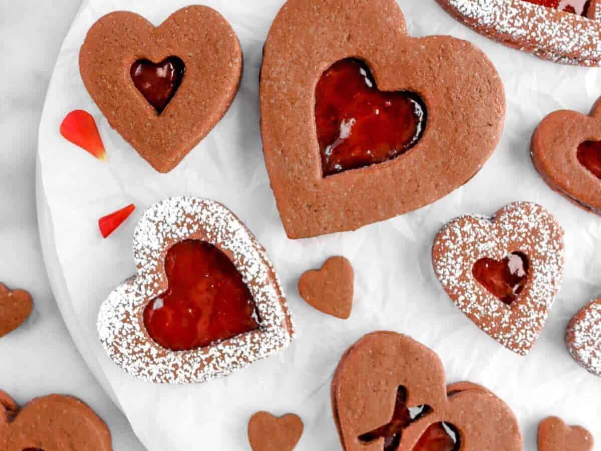 Valentine's day cookies with raspberry jam on a white plate.