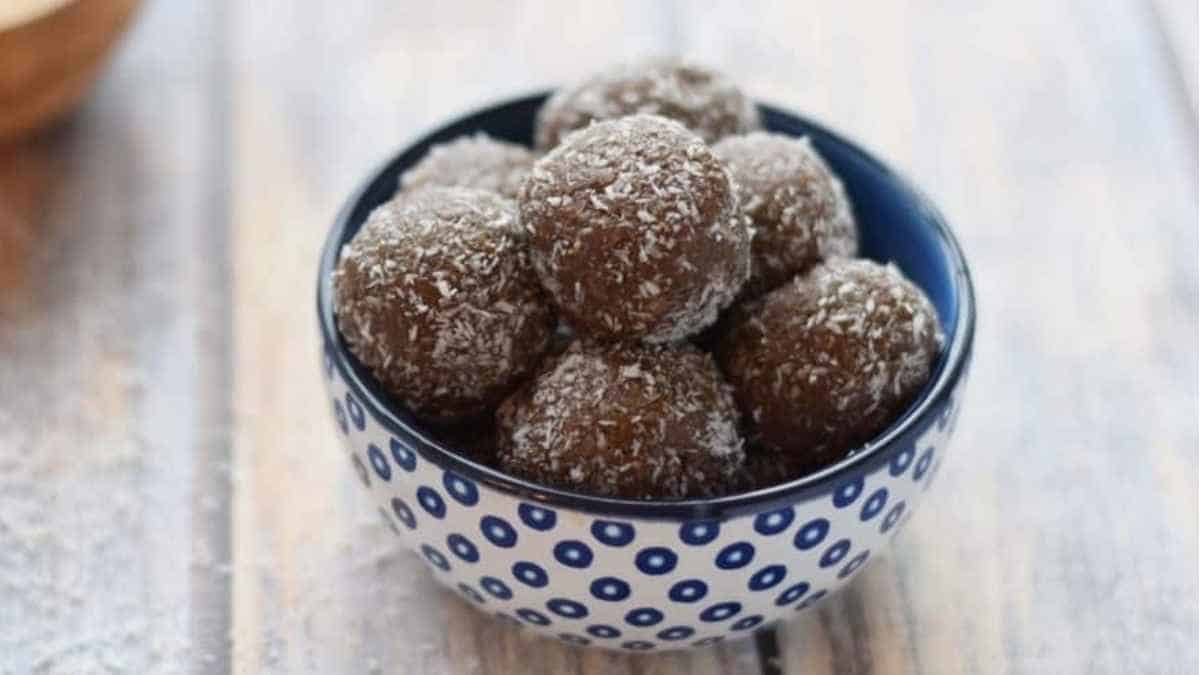 Chocolate coconut balls in a blue and white bowl.