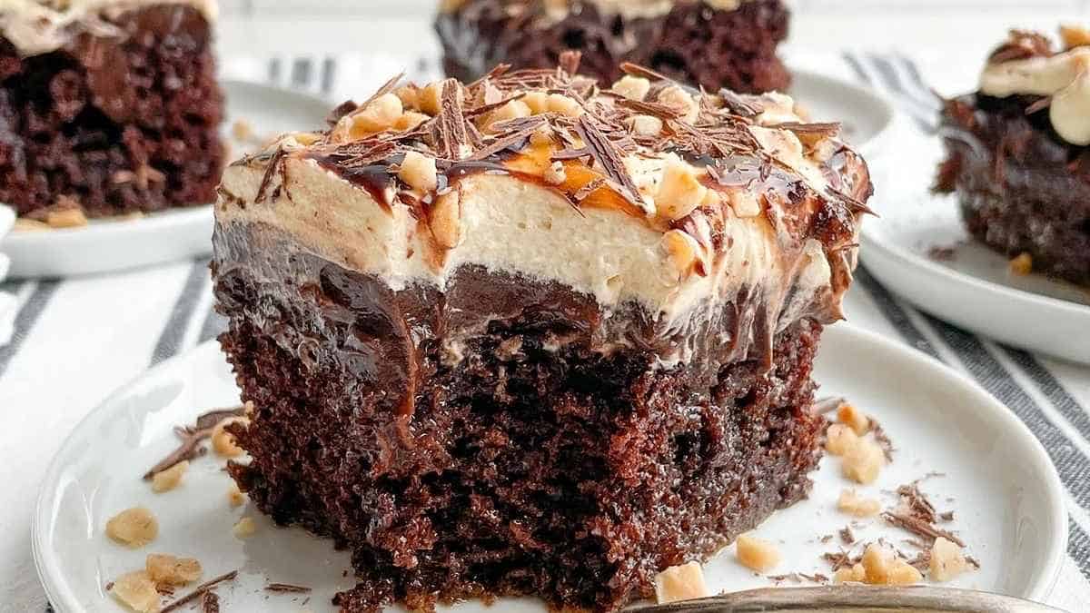 A slice of chocolate cake with peanut butter frosting on a plate.