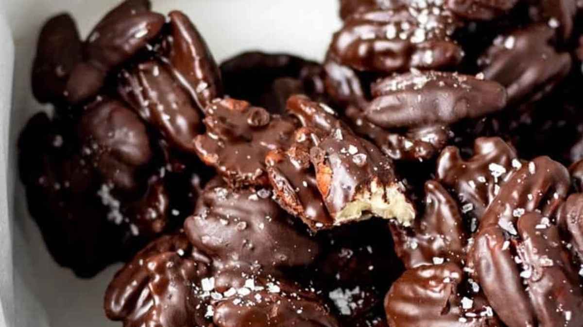 Chocolate covered walnuts in a white bowl.