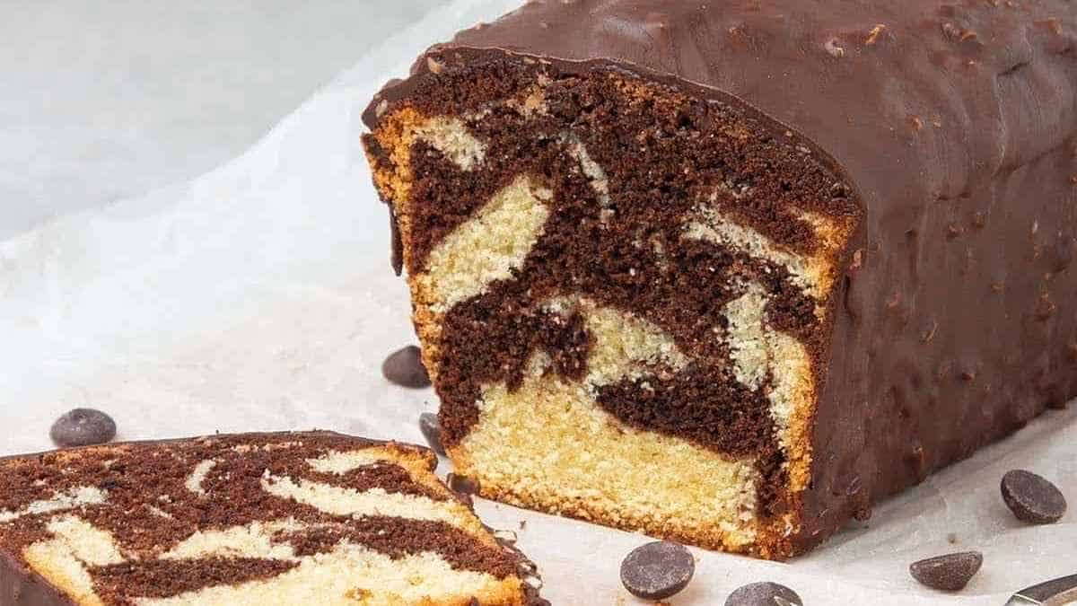 A slice of chocolate cake with chocolate chips on top.