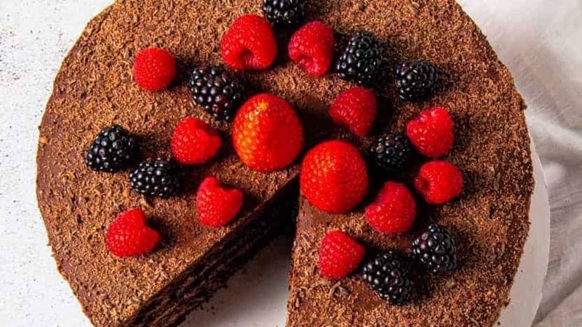A chocolate cake with strawberries and raspberries on a plate.