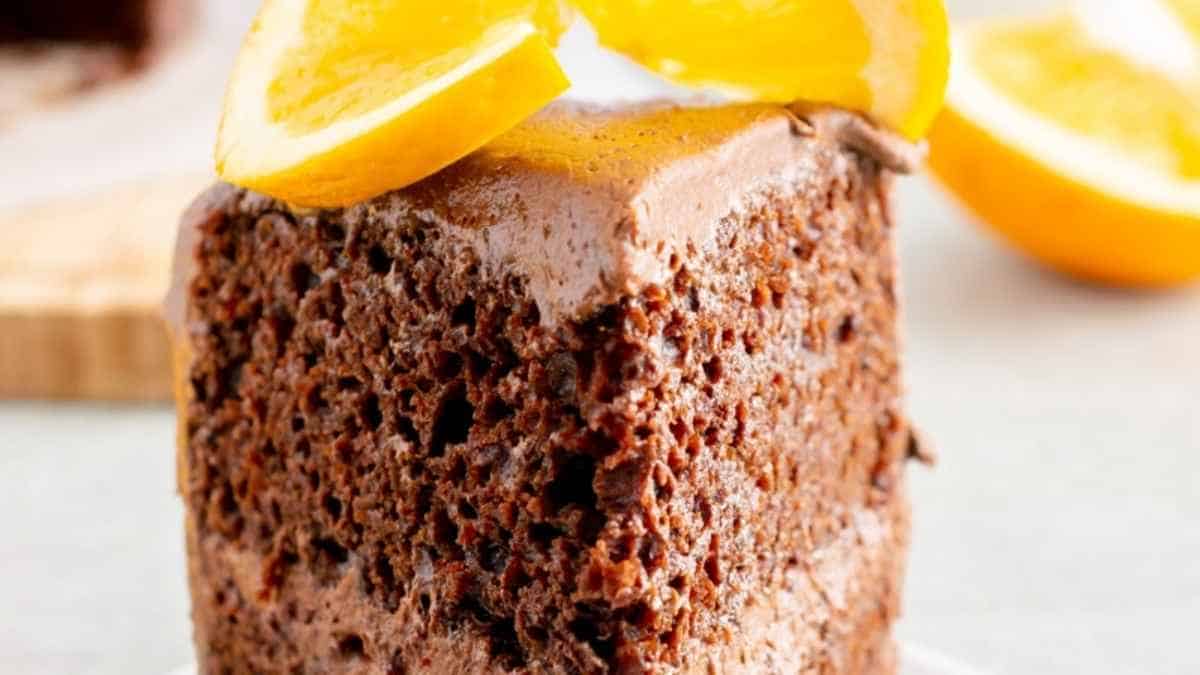 A slice of chocolate cake with orange slices on top.