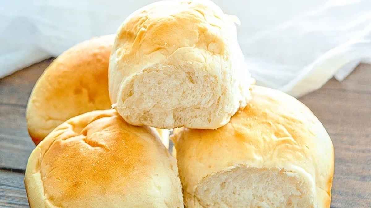 A stack of bread rolls on top of a wooden surface.