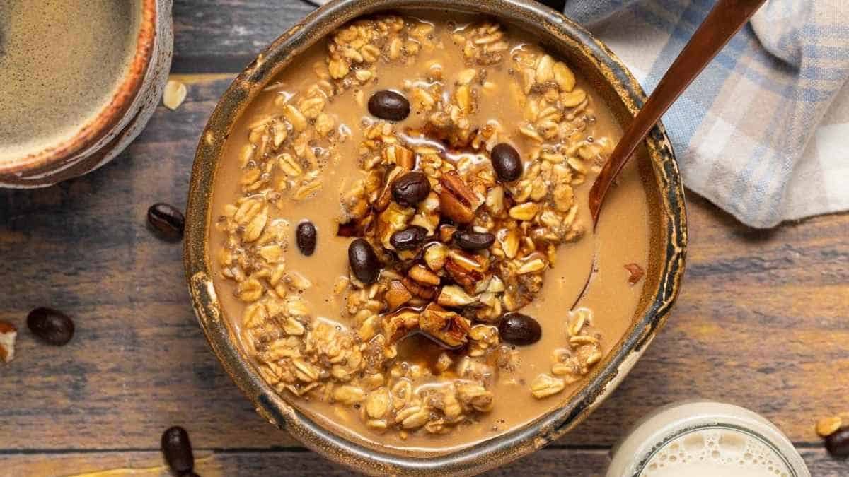 A bowl of oatmeal with coffee and nuts.