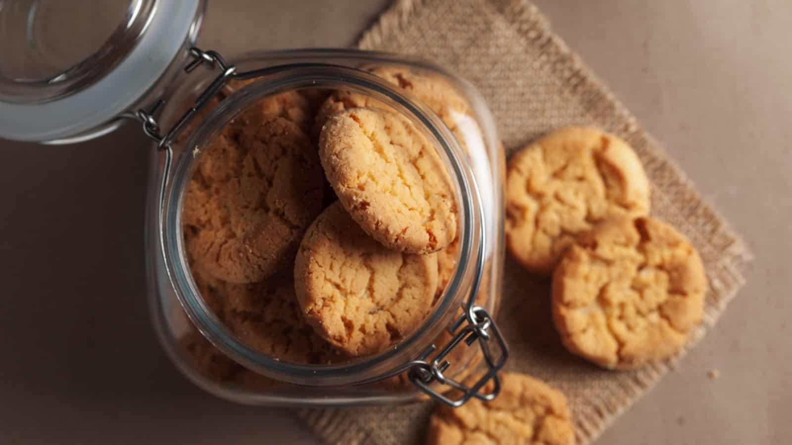 Cookies in a glass jar on a brown table.