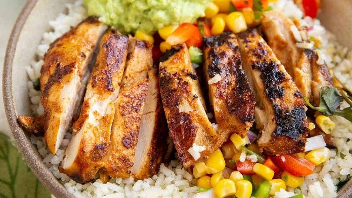 Grilled chicken with rice and guacamole in a bowl.