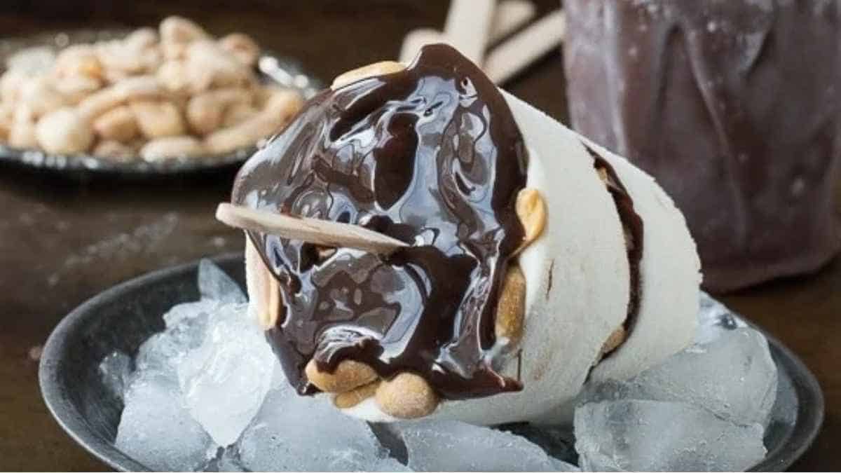 A dessert with chocolate and peanuts on top of ice.