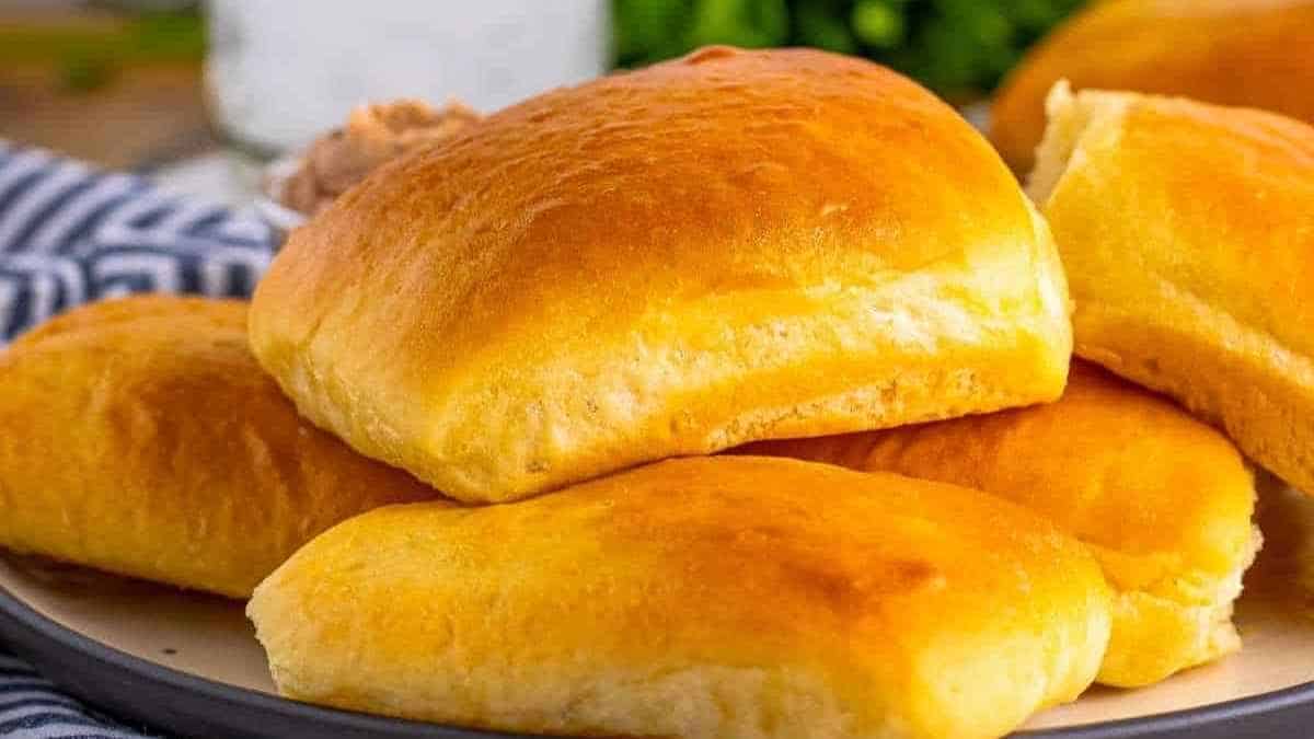 Bread rolls on a plate with a glass of water.