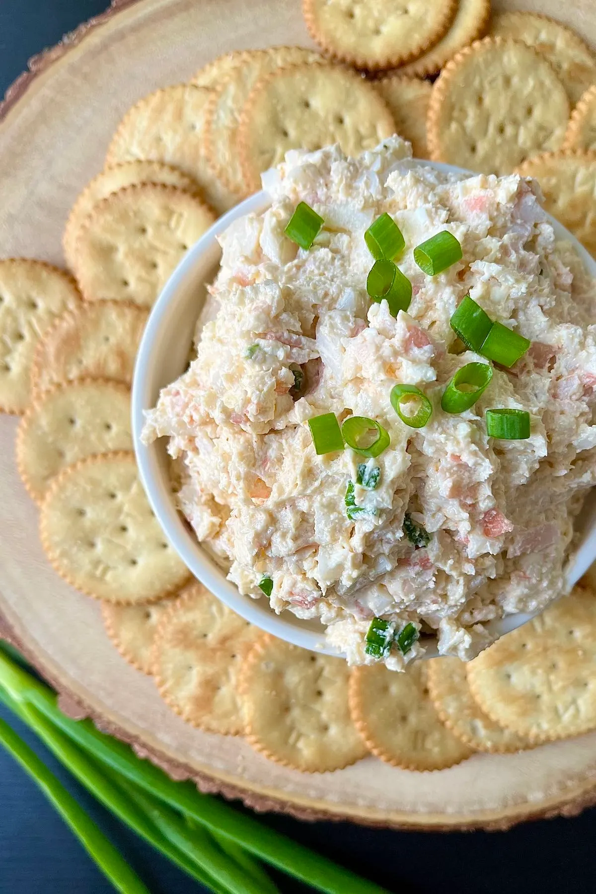 A bowl of dip with crackers and imitation crab.