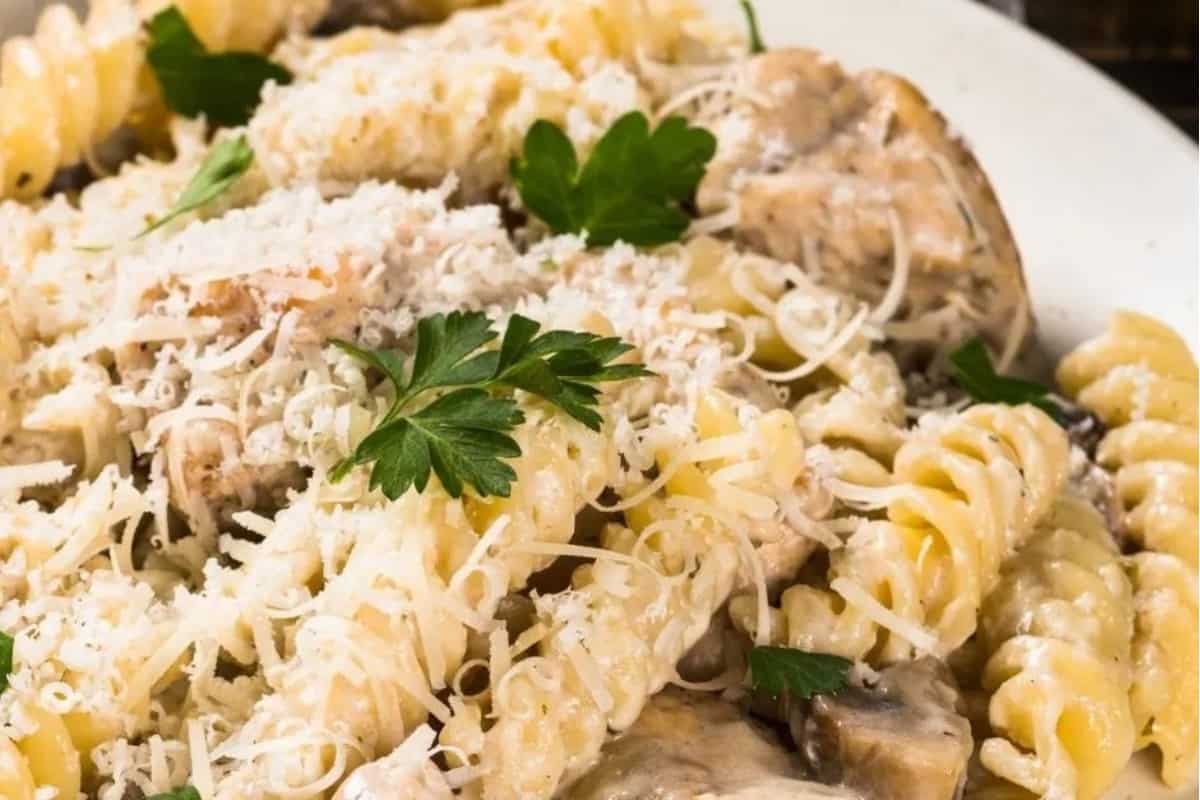 A plate of pasta with mushrooms and parmesan.