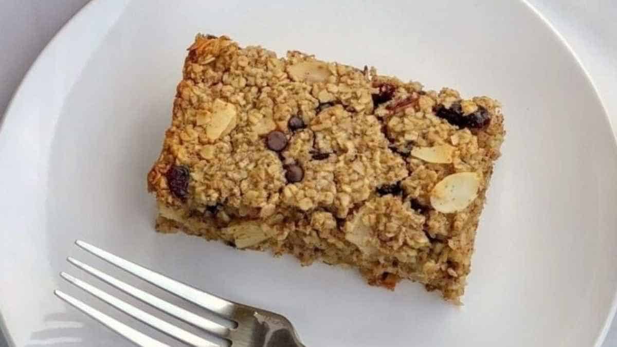 A piece of oatmeal cake on a plate with a fork.