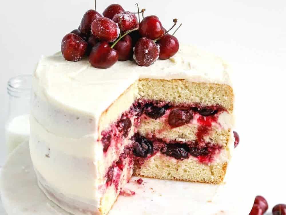 A cherry layer cake with a slice taken out.