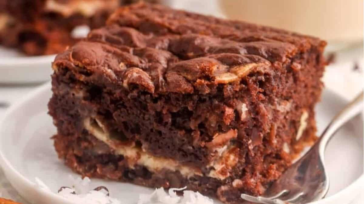 A slice of chocolate cake on a plate with a fork.