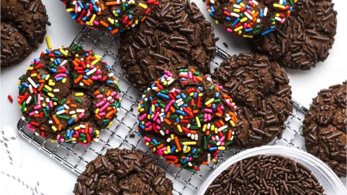 Chocolate cookies with sprinkles on a cooling rack.