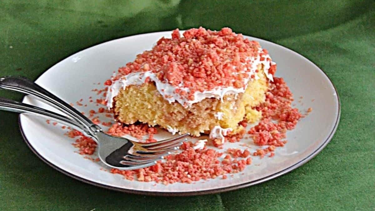 A piece of cake with pink sprinkles on a plate.