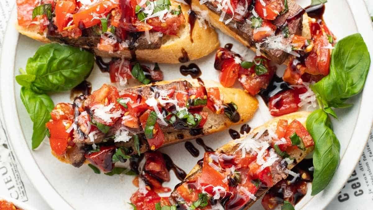 A plate of bruschetta with tomatoes and basil.