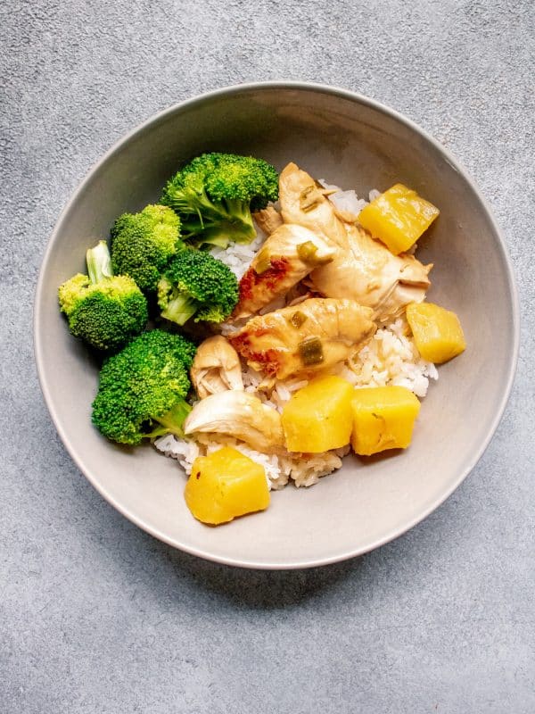 A bowl with rice, broccoli, pineapple and chicken tender recipes.