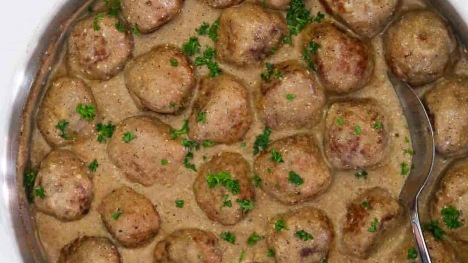 A dish with meatballs and gravy on a white plate.