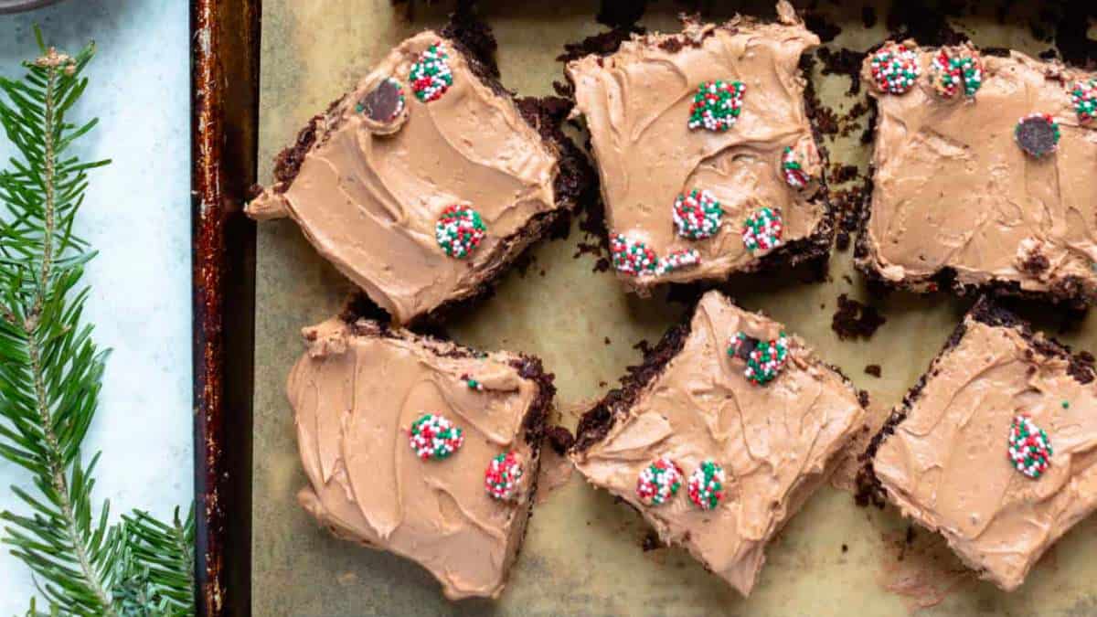 A baking sheet with brownies and frosting on it.