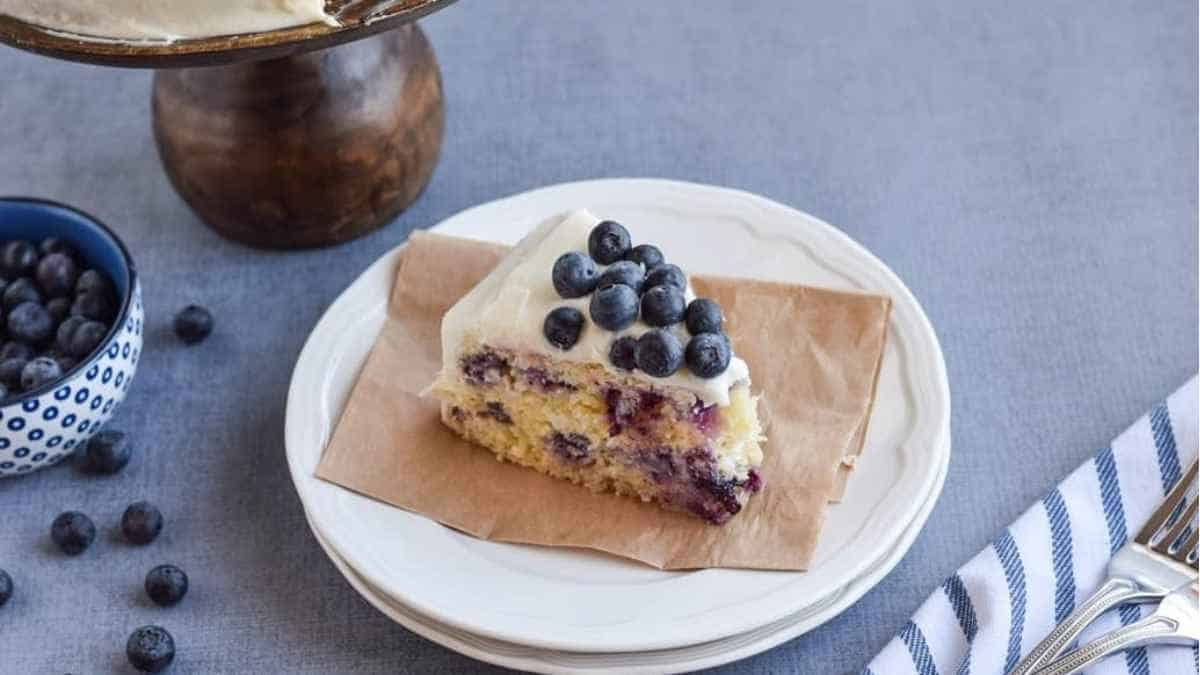 A piece of cake with blueberries on top.