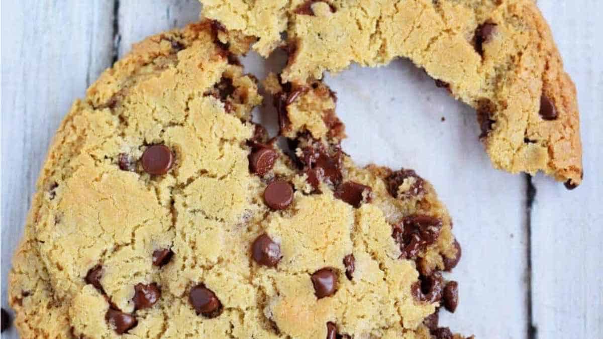 A chocolate chip cookie with a bite taken out of it.