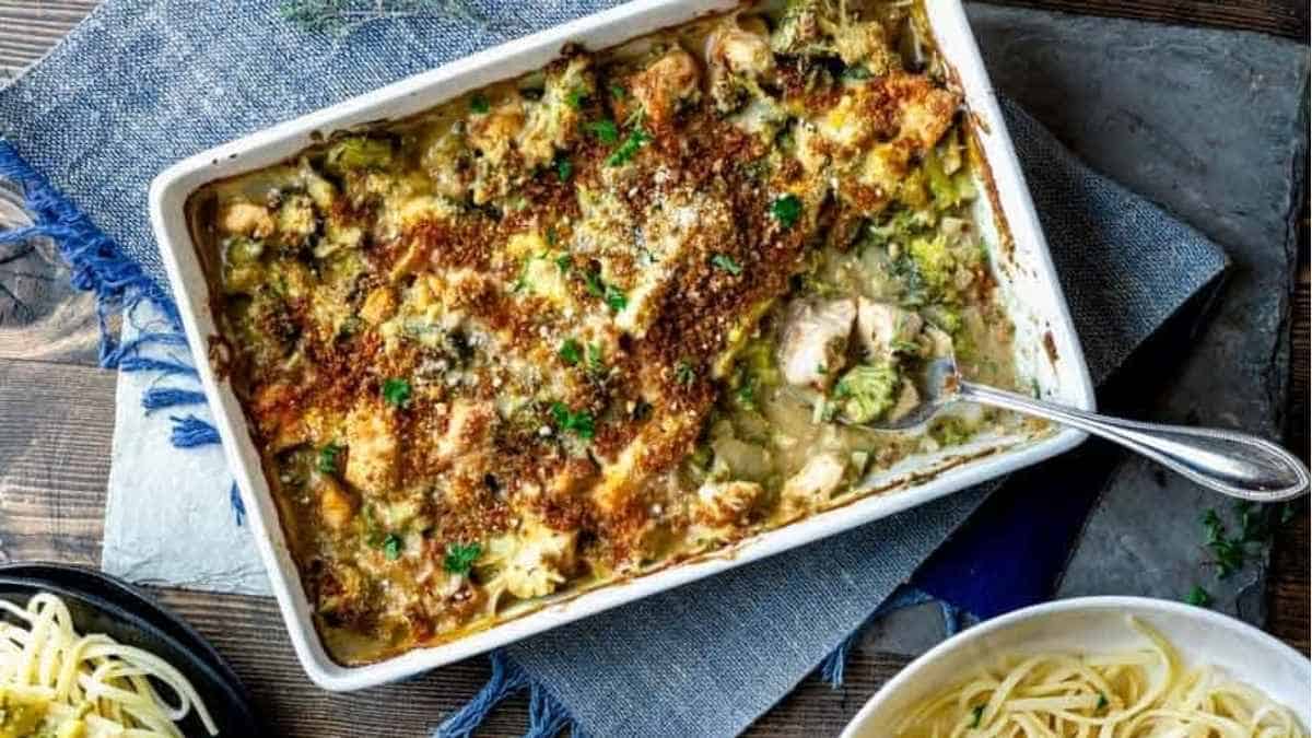 A casserole dish with chicken, broccoli and pasta.
