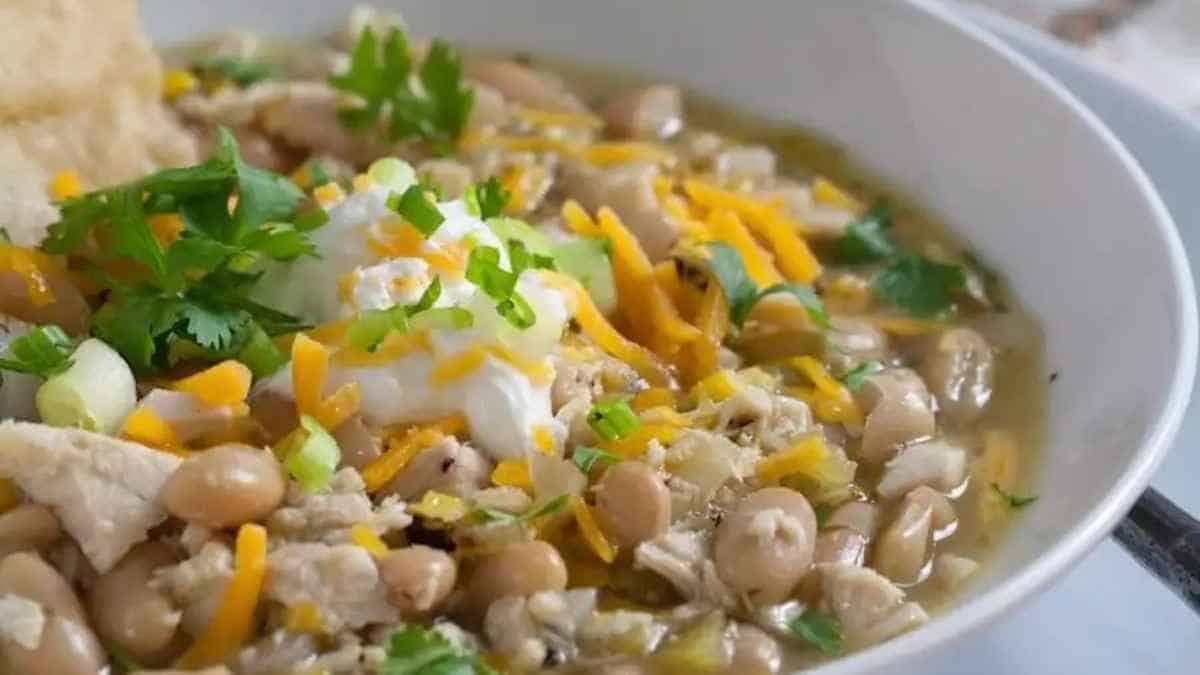 Chicken and white bean soup in a bowl with tortilla chips.