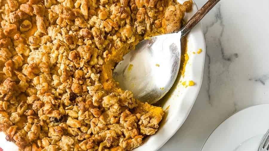 A plate of pumpkin crisp with a fork on it.