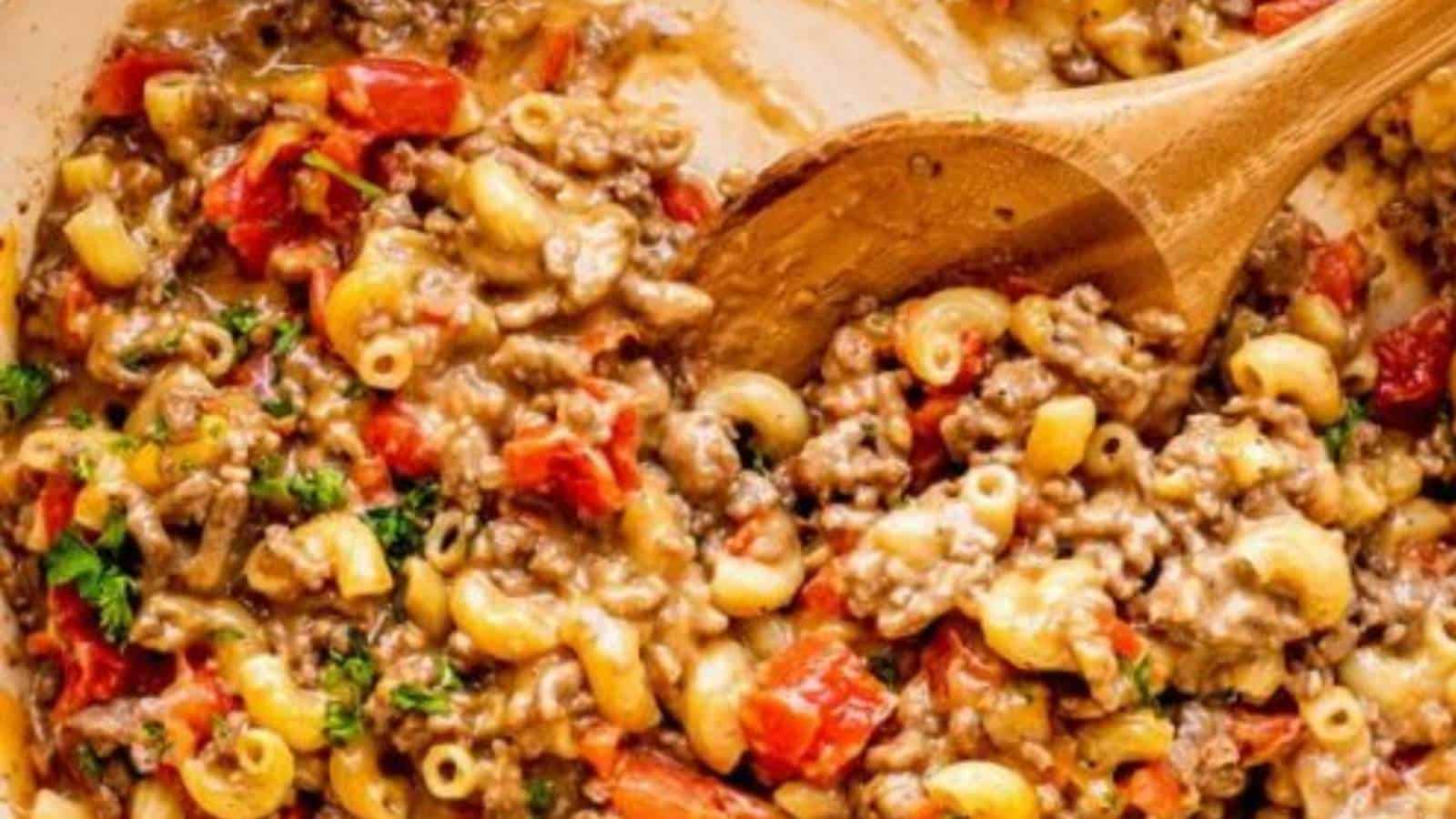 Macaroni and cheese in a pan with a wooden spoon.