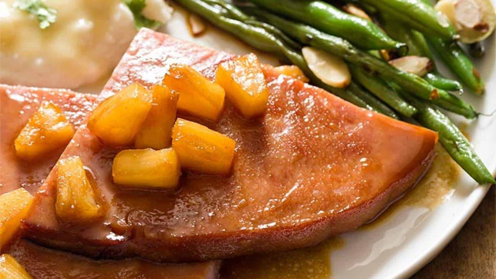 A plate with ham and green beans on it.