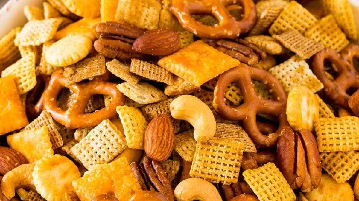 A bowl of chex mix with nuts and pretzels.