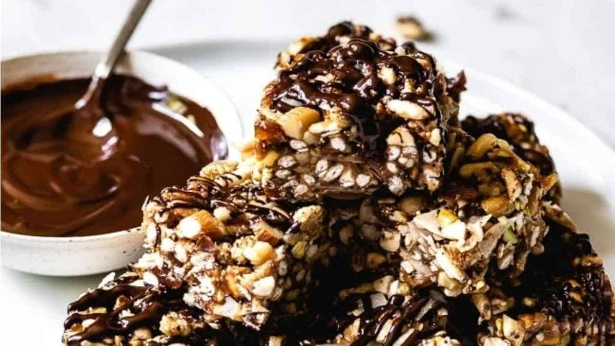 A stack of granola bars with chocolate sauce on top.