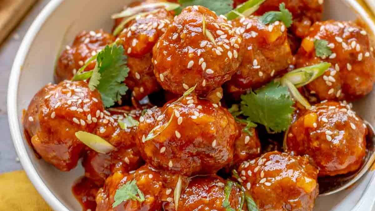 Asian meatballs on a plate with a fork.
