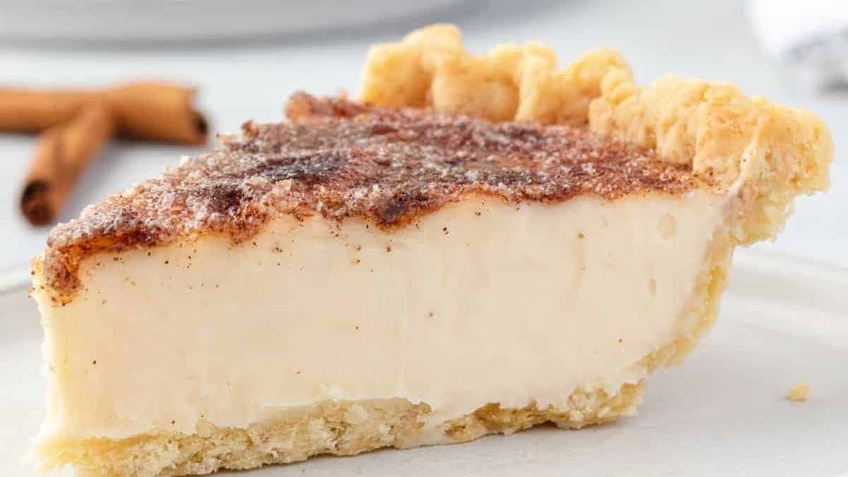 A slice of cinnamon cream pie on a white plate.