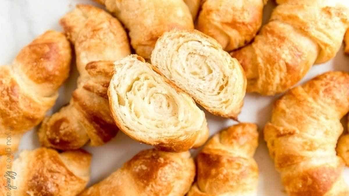 A plate of croissants on a white surface.