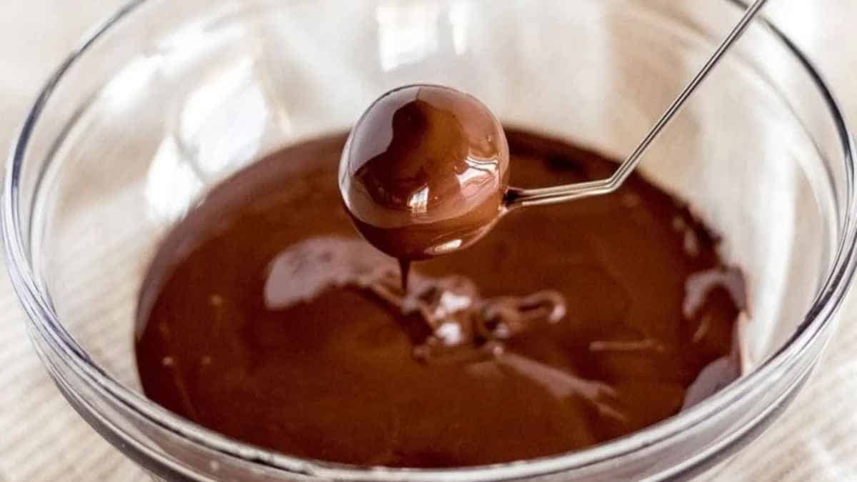 A spoon is being used to stir chocolate into a bowl.