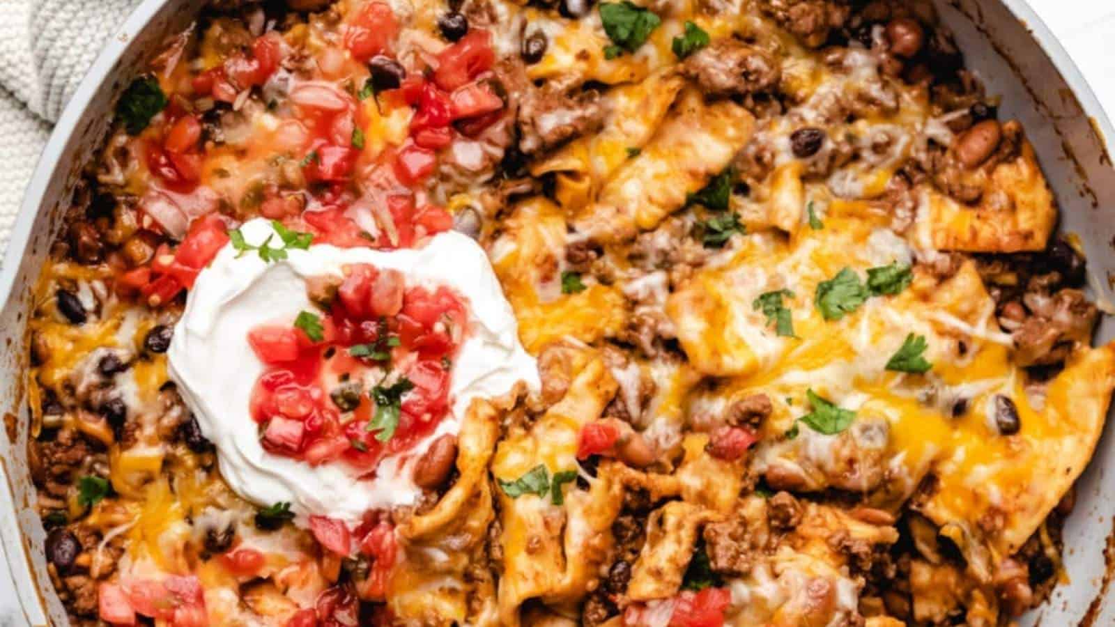Mexican nachos in a skillet with sour cream.
