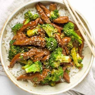 A bowl of broccoli and chicken stir fry with chopsticks.