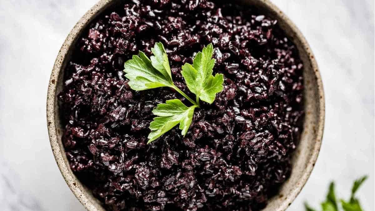 Black rice in a bowl with parsley.