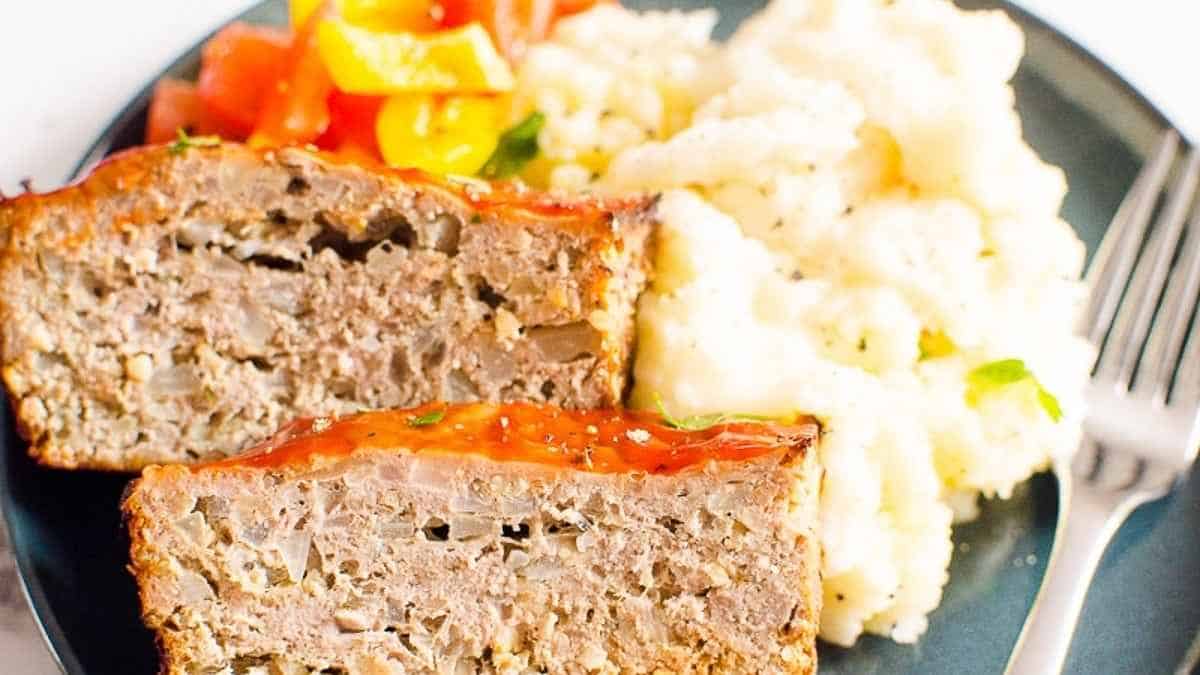 Meatloaf and mashed potatoes on a plate.