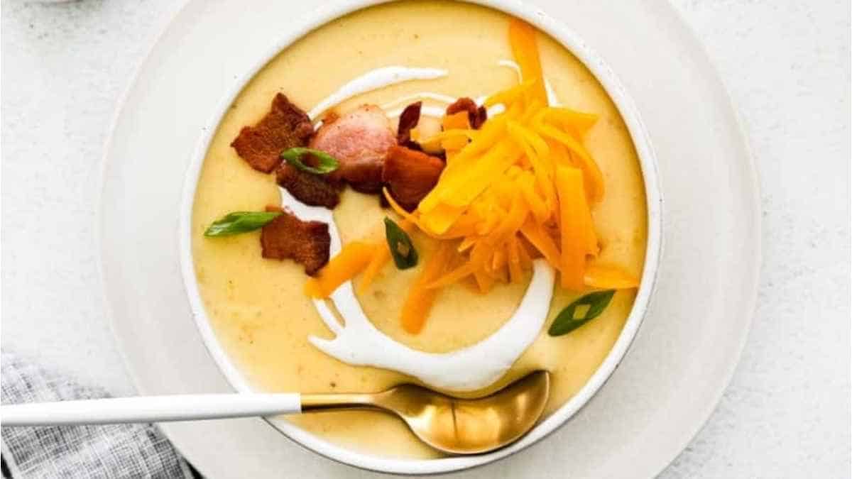 A bowl of soup with bacon, cheese and sour cream.