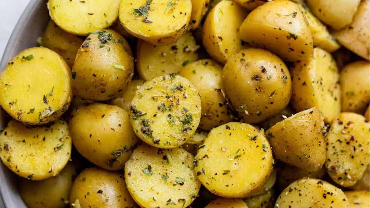 Roasted potatoes in a bowl with herbs.