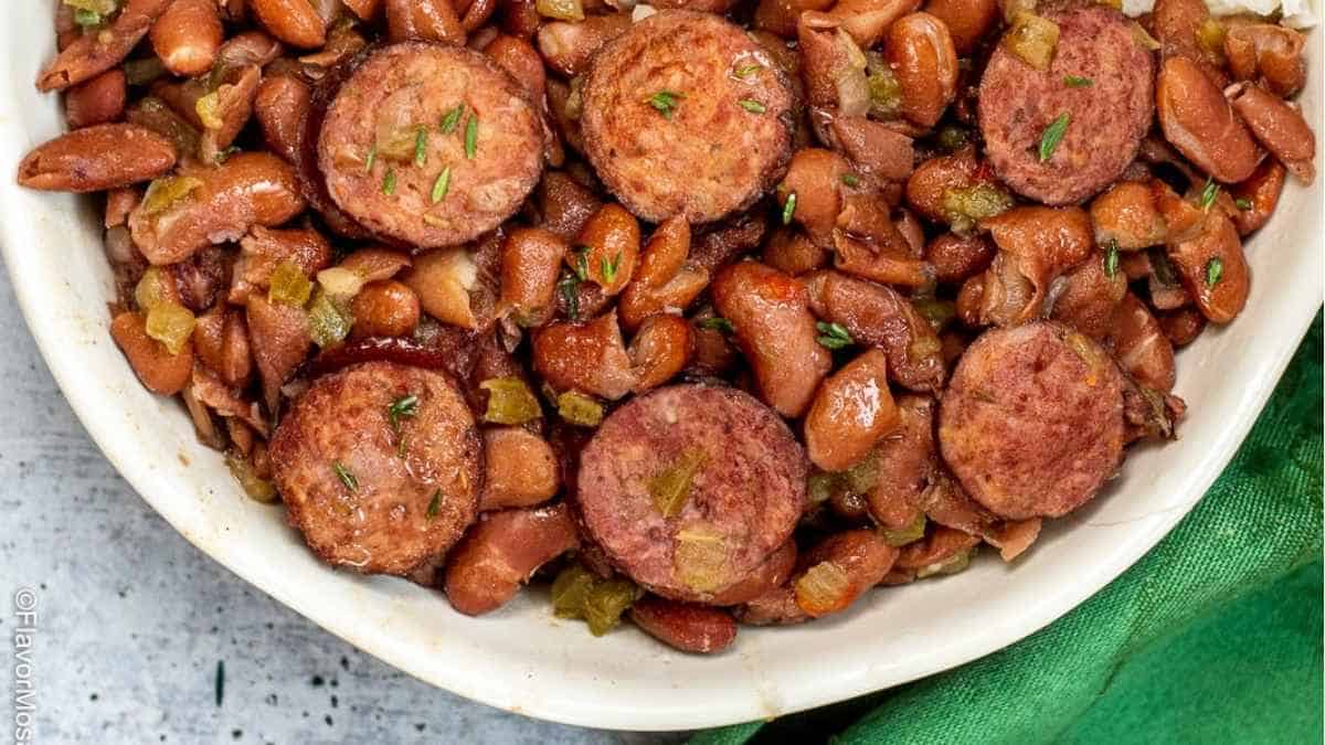 Sausage and beans in a white bowl.